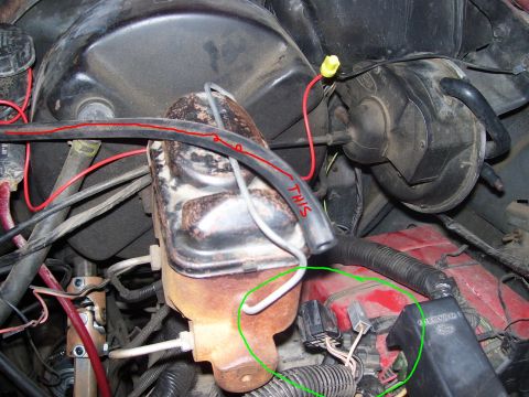 1986 Ford Bronco - Engine bay view focusing on the brake master cylinder and surrounding components, with some handwritten markings on a hose.