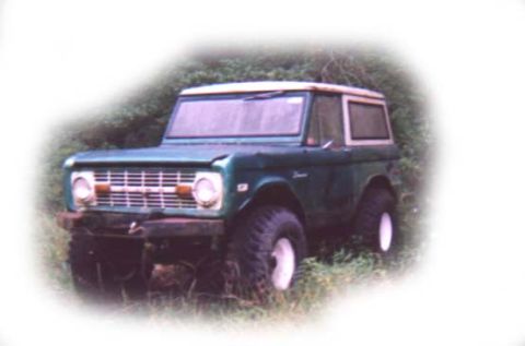 1973 Ford Bronco - A 1973 Ford Bronco is shown from a three-quarter front angle, parked in a grassy area.