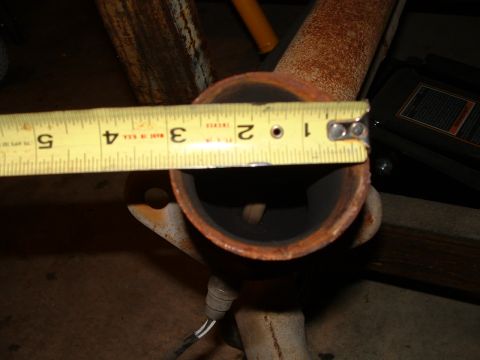 1995 Ford Bronco - Measuring the diameter of a rusted exhaust pipe. Supermotors.net logo in corner.