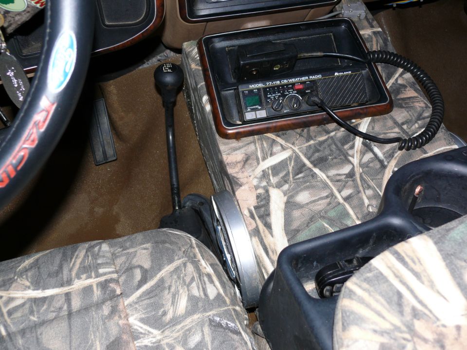 Interior view of camouflage seat covers, CB radio, and gear shift