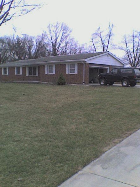 1995 Ford Bronco - A black Ford Bronco is parked in front of a suburban home with a garage.