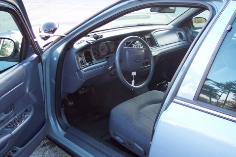 2001 Ford Crown Victoria - The interior of a 2001 Ford Crown Victoria is visible through the open driver's side door.