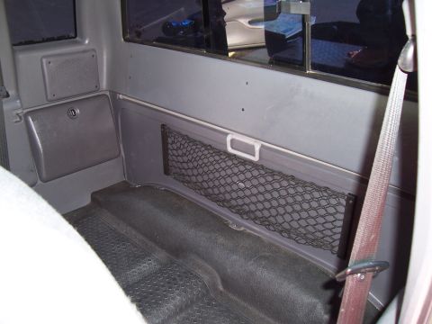 2003 Ford Ranger - The interior of a truck cab shows a storage net on the wall and a seatbelt. No year-identifying features are visible.