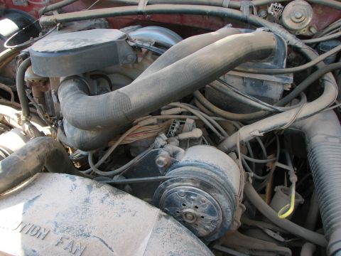 1986 Ford Bronco - Close-up view of a dusty engine bay showing various components and wiring.
