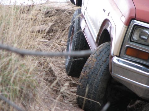 1986 Ford Bronco - SUV with off-road tires navigating a dirt path.