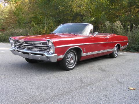 1967 Ford Galaxie - Red 1967 Ford Galaxie convertible parked on asphalt with trees in the background.