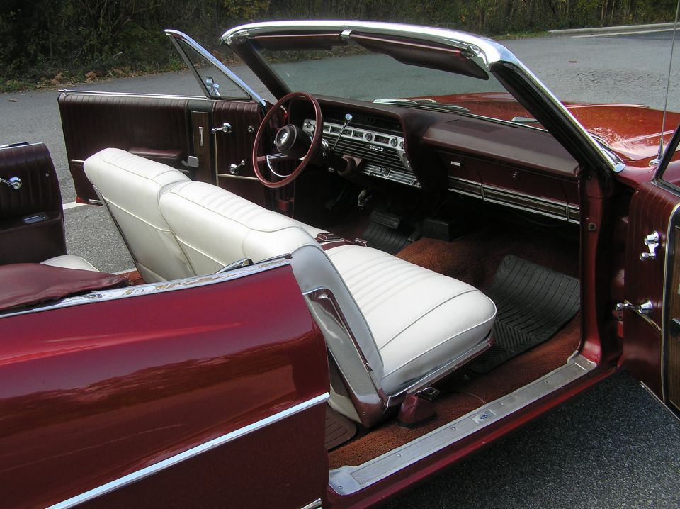 Maroon convertible interior with white seats and dashboard, top down