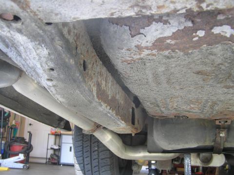 1967 Ford Galaxie - Rear driver's side framerail. In the foreground is the pan of the trunk which has surface rust. Just past the pan of the trunk is the gasol…