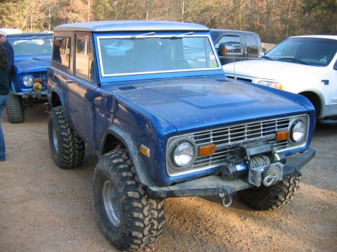 1992 Ford Mustang - A lifted blue Ford Bronco is parked outdoors with another Bronco behind it.
