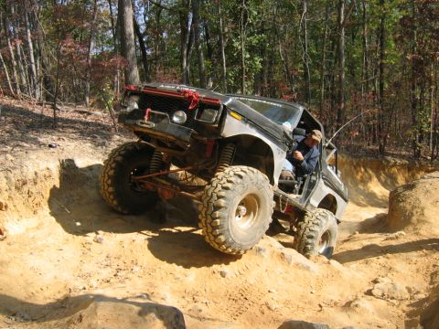 1992 Ford Mustang - This heavily modified off-road vehicle navigates a challenging dirt trail.