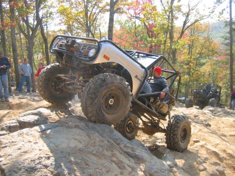 1992 Ford Mustang - A modified off-road vehicle navigates a rocky trail during an autumn day.