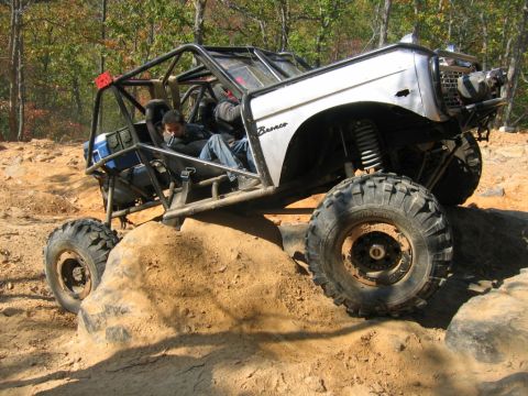 1992 Ford Mustang - This heavily modified off-road vehicle navigates a challenging rocky terrain, its robust suspension and large tires.