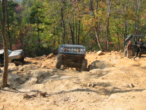1992 Ford Mustang - Off-road vehicles navigate a challenging rocky trail during autumn.