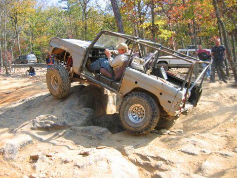 1992 Ford Mustang - This heavily modified off-road vehicle navigates a rocky trail with a driver and passenger inside.