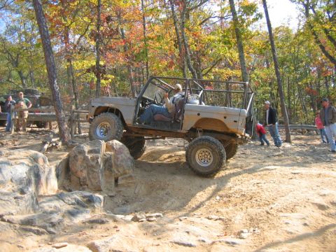 1992 Ford Mustang - A modified Ford Bronco navigates a rocky trail with onlookers present.