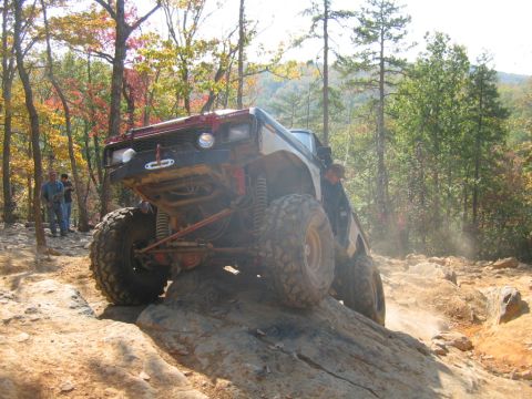 1992 Ford Mustang - An off-road vehicle navigates a rocky trail during autumn, kicking up dust.