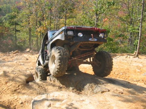1992 Ford Mustang - An off-road vehicle navigates a rocky trail during autumn.