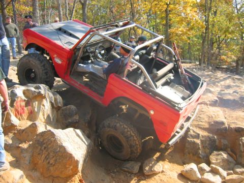 1992 Ford Mustang - Off-road vehicle navigates a rocky obstacle course during an outdoor event.