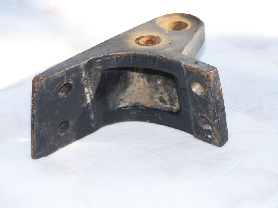 Black steel Ford bracket stamped E7TB1478A with bolt holes, on white cloth