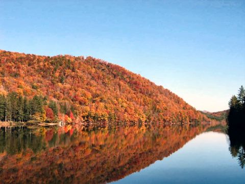 1985 Ford LTD Crown Victoria - A lake mirrors a hillside ablaze with the vibrant colors of fall foliage.