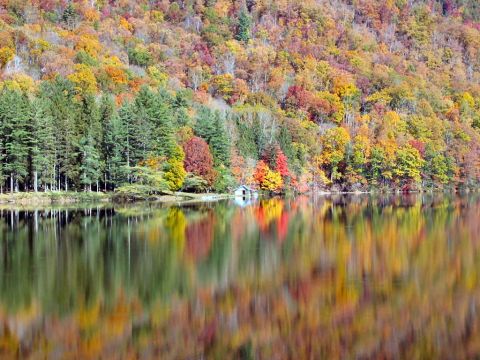 1985 Ford LTD Crown Victoria - Autumn colors paint the hillside and reflect in the water, with a tiny boathouse visible.