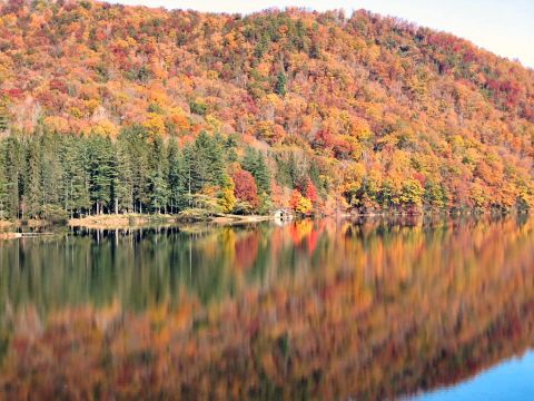 1985 Ford LTD Crown Victoria - A lake mirrors a hillside ablaze with the vibrant colors of fall foliage.