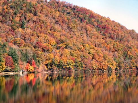 1985 Ford LTD Crown Victoria - Autumn colors reflect on the water's surface, with a small structure near the lake's edge.