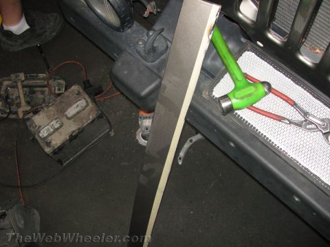 1987 Suzuki Samurai - Tools and a removed battery are near the front of a Jeep, suggesting repair work.