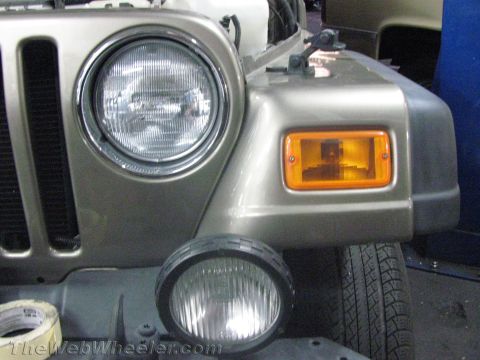 1987 Suzuki Samurai - Close-up of a Jeep Wrangler's front corner, showing the headlight and turn signal assembly.