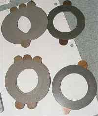 1996 Ford Bronco - Four circular metal shims with wooden dowels are shown on a white surface, with a SuperMotors logo at the bottom.