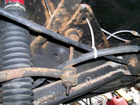 1995 Mercury Grand Marquis - Close-up of heavily rusted vehicle suspension components, including a sway bar end link and shock absorber.