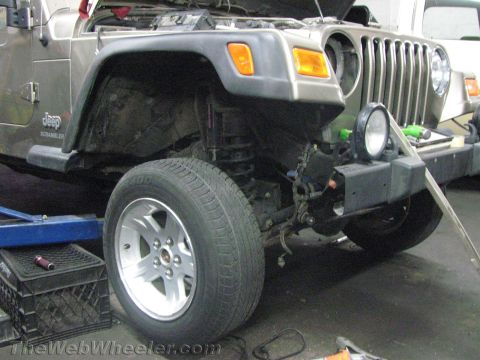 1987 Suzuki Samurai - Front view of a Jeep Wrangler with its hood open, undergoing service or repair.