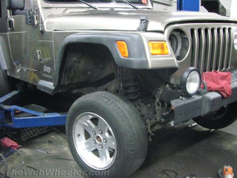 1987 Suzuki Samurai - Front end of a Jeep Wrangler undergoing repairs in a workshop.