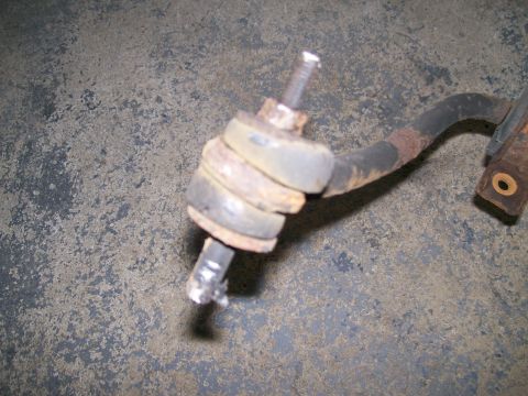 1995 Mercury Grand Marquis - A close-up view of a corroded sway bar end link, showing wear on the rubber bushings.