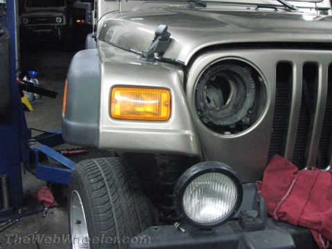 1987 Suzuki Samurai - Front end of a Jeep Wrangler with the headlight assembly removed, showing the grille and fender.