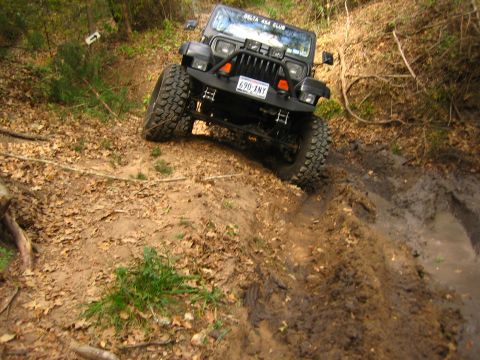 2001 Jeep Wrangler - Black Jeep Wrangler navigates a muddy off-road trail, displaying a "DELTA 4X4 CLUB" sticker.