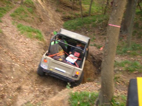 2001 Jeep Wrangler - An off-road vehicle navigates a steep dirt path surrounded by trees.