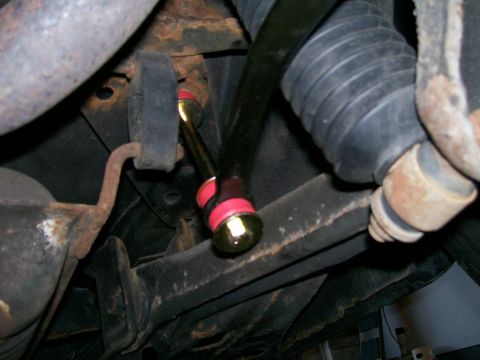 1995 Mercury Grand Marquis - Close-up view of a rear sway bar with red bushings and gold hardware, likely an aftermarket upgrade.