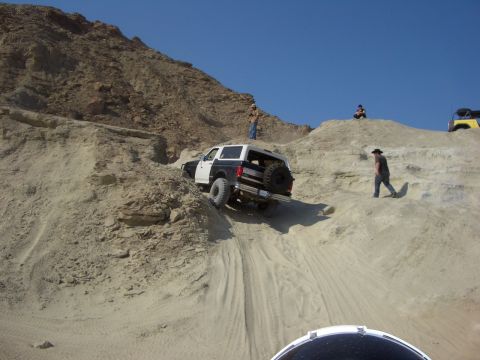 1985 Ford Bronco - Off-roading in a 1987 Ford Bronco, navigating a steep, sandy incline with people watching.