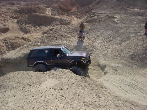 1985 Ford Bronco - This 1985 Ford Bronco navigates a challenging sandy incline, its off-road capabilities.