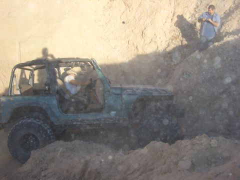 1985 Ford Bronco - Jeep Wrangler TJ navigating a dirt trail with a person driving.