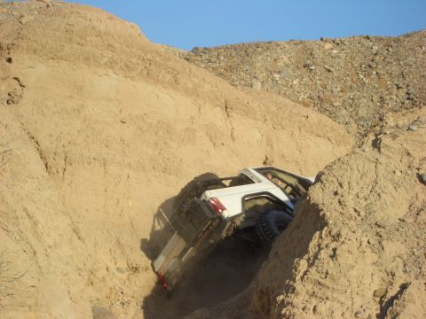 1985 Ford Bronco - This 1985 Ford Bronco tackles a challenging off-road course, demonstrating its capabilities on steep, sandy terrain.