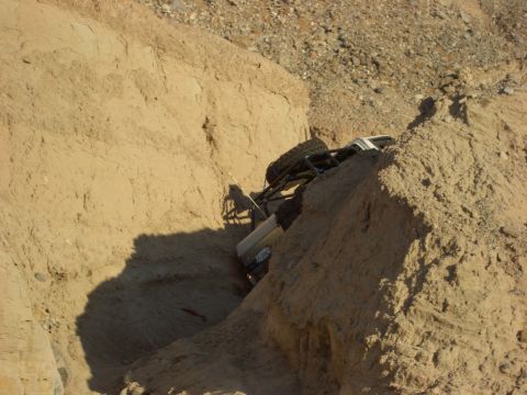 1985 Ford Bronco - Vehicle stuck in a steep, sandy embankment after an off-road excursion.