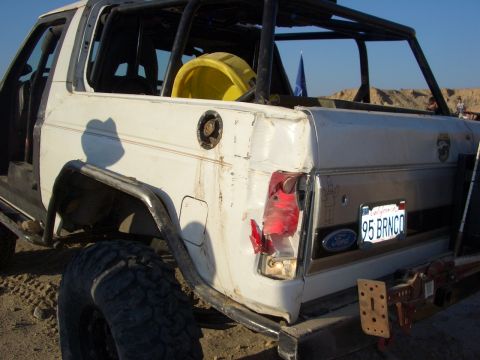 1985 Ford Bronco - The rear of a modified Ford Bronco shows a custom roll cage and a license plate indicating '95.