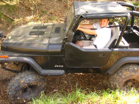 2001 Jeep Wrangler - A man drives a black Jeep Wrangler off-road.