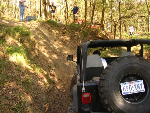 2001 Jeep Wrangler - A 2001 Jeep Wrangler navigates a steep, wooded trail with several people watching.