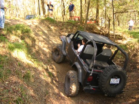 2001 Jeep Wrangler - A driver navigates a steep, wooded trail in a Jeep Wrangler.