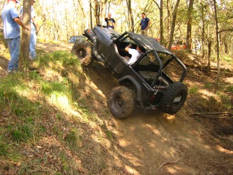 2001 Jeep Wrangler - A black 2001 Jeep Wrangler navigates a challenging off-road trail with spectators watching.