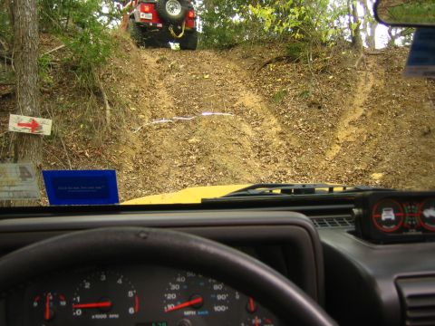 2001 Jeep Wrangler - Two Jeep Wranglers navigate a challenging off-road trail, with one ascending a steep, rutted incline.