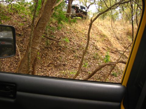 2001 Jeep Wrangler - A 2001 Jeep Wrangler navigates a steep, wooded incline.